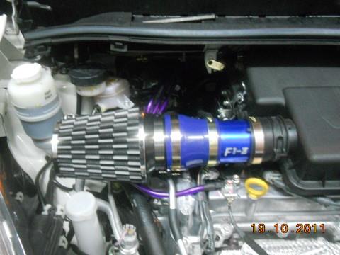 DA NE ZABORAVIM F1-Z KOMPRESUJE VAZDUH U MOTOR <br /><br />Ovaj sistem ili u slobodnom prevodu prirodna turbina je sistem koji koriste trkacki automobili, a svodi se na jednostavan princip da se usisna grana (uz posredstvo odgovarajucih filtera) izvede direktno negde na spoljni deo automobila koji je okrenut smeru kretanja i time se povecanjem brzine automobila proporcionalno povecava pritisak vazduha koji ulazi u motor. Na primer F1 bolidi imaju usis direktno iznad glave vozaca, GT automobili imaju "grbe" na haubi koje direktno ubacuju vazduh u motor automobila, a taj pritisak je direktno srazmeran brzini kretanja automobila.Tu nastupa F1-Z. <br />Osnove: <br />Najlakši nacin da dobijete više snage iz motora je da povecate kolicinu vazduha i goriva koje motor može da sagori. Jedan od nacina je da se poveca zapremina bilo povecanjem zapremine cilindara ili dodavanjem cilindara. Ako taj nacin nije moguc ili isplativ, turbo punjac je jednostavnije i kompaktnije rešenje. <br />Turbo punjaci omogucavaju motoru da sagori više goriva i vazduha tako što u postojecu zapreminu motora sabijanjem ubacuje više goriva i vazduha. Mera za sabijenost je u barima (metricki sistem) ili psi (kolonijalni sistem - funte po kvadratnom incu). <br />1bar = 14,503 psi tj. 1psi = 0.068947 bar. <br />Tipican pritisak turbina je obicno oko 6-8 psi tj. oko 0,5 bar što znaci da se u motor ubacuje 50% više vazduha (1 bar je normalan pritisak, a kada dodate 0,5 bar pritiska pomocu turba dobijate 1,5 bar tj. 50% povecanja pritiska). Za ocekivati je da ce i snaga skociti za 50%, medutim sistem nije 100% efikasan tako da su povecanja snage u okviru 30 – 40% u zavisnosti od konstrukcije.