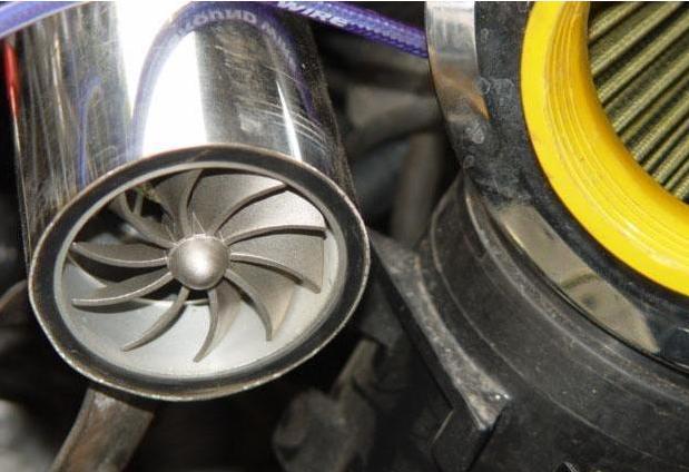 DA NE ZABORAVIM F1-Z KOMPRESUJE VAZDUH U MOTOR <br /><br />Ovaj sistem ili u slobodnom prevodu prirodna turbina je sistem koji koriste trkacki automobili, a svodi se na jednostavan princip da se usisna grana (uz posredstvo odgovarajucih filtera) izvede direktno negde na spoljni deo automobila koji je okrenut smeru kretanja i time se povecanjem brzine automobila proporcionalno povecava pritisak vazduha koji ulazi u motor. Na primer F1 bolidi imaju usis direktno iznad glave vozaca, GT automobili imaju "grbe" na haubi koje direktno ubacuju vazduh u motor automobila, a taj pritisak je direktno srazmeran brzini kretanja automobila.Tu nastupa F1-Z. <br />Osnove: <br />Najlakši nacin da dobijete više snage iz motora je da povecate kolicinu vazduha i goriva koje motor može da sagori. Jedan od nacina je da se poveca zapremina bilo povecanjem zapremine cilindara ili dodavanjem cilindara. Ako taj nacin nije moguc ili isplativ, turbo punjac je jednostavnije i kompaktnije rešenje. <br />Turbo punjaci omogucavaju motoru da sagori više goriva i vazduha tako što u postojecu zapreminu motora sabijanjem ubacuje više goriva i vazduha. Mera za sabijenost je u barima (metricki sistem) ili psi (kolonijalni sistem - funte po kvadratnom incu). <br />1bar = 14,503 psi tj. 1psi = 0.068947 bar. <br />Tipican pritisak turbina je obicno oko 6-8 psi tj. oko 0,5 bar što znaci da se u motor ubacuje 50% više vazduha (1 bar je normalan pritisak, a kada dodate 0,5 bar pritiska pomocu turba dobijate 1,5 bar tj. 50% povecanja pritiska). Za ocekivati je da ce i snaga skociti za 50%, medutim sistem nije 100% efikasan tako da su povecanja snage u okviru 30 – 40% u zavisnosti od konstrukcije.